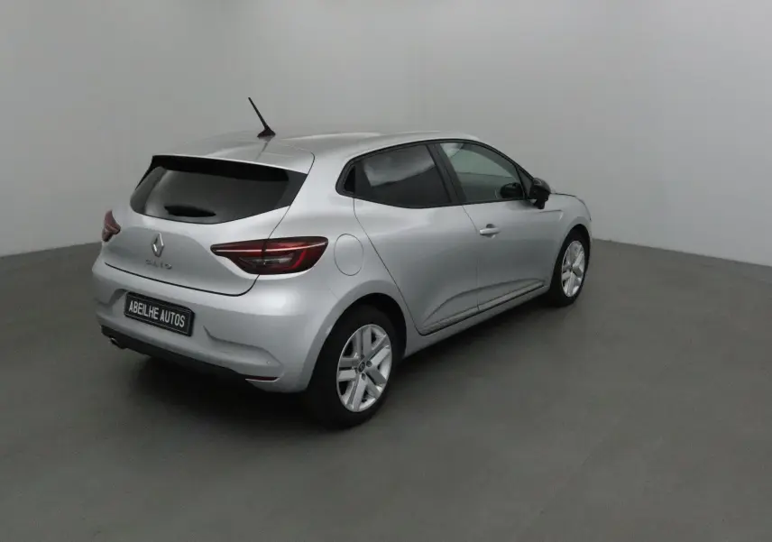 Renault Clio V gris platine vue 3/4 arrière droit dans un studio, avec vitres teintées et jantes alliage.