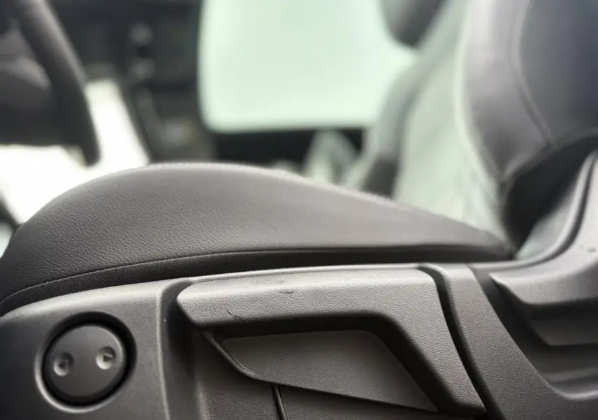 Détail du réglage manuel de l'accoudoir central en cuir noir dans l'habitacle du Nissan Qashqai 2025.