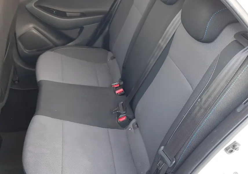 Vue intérieure côté droit des sièges arrière gris et noirs de la Hyundai i20 blanche, avec ceintures de sécurité visibles.