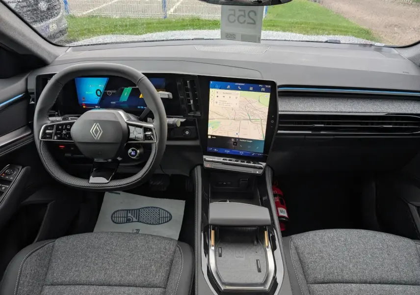 Vue intérieure avant du tableau de bord et volant du Renault Austral gris, avec écran tactile central et affichage numérique.