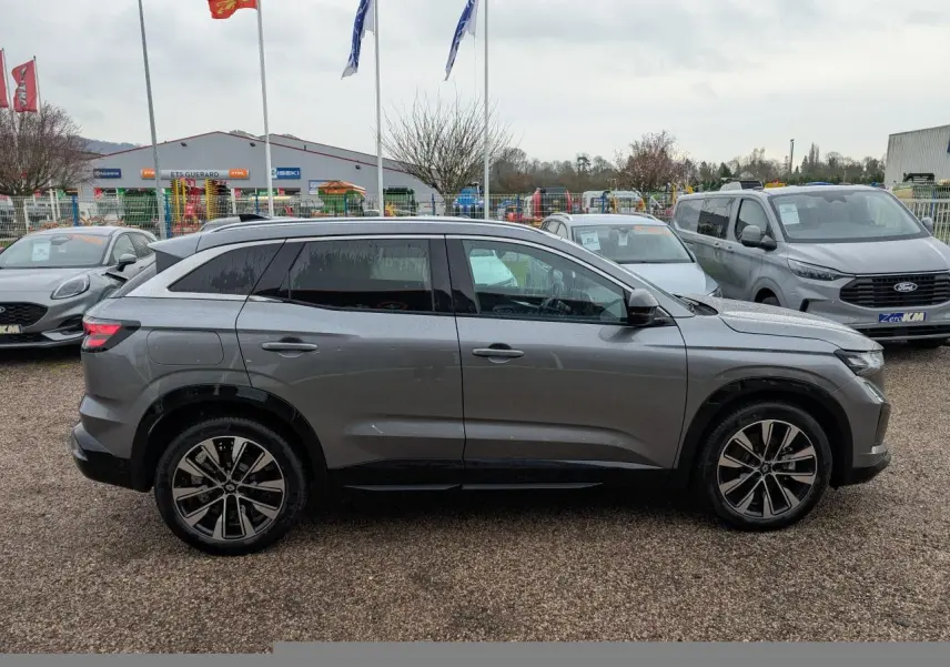 Renault Austral gris en vue de profil côté gauche, avec jantes alliage noires et vitres arrière surteintées.