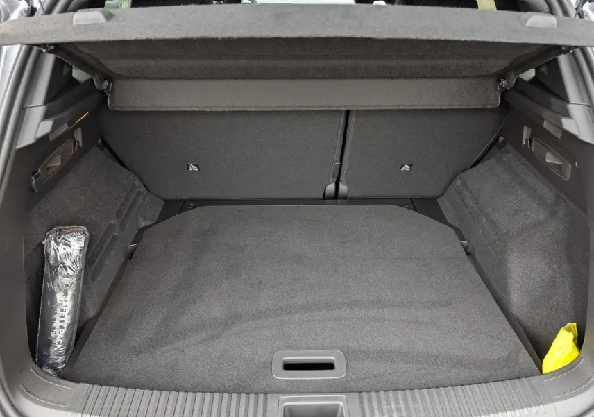 Vue intérieure du coffre du Renault Austral gris, montrant la surface de chargement avec cache-bagages et rangement latéral.
