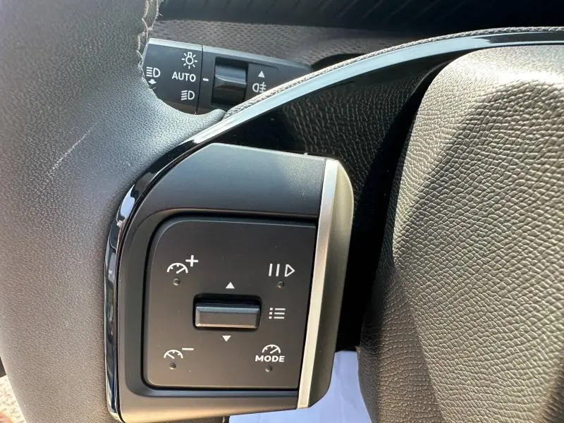 Détail des commandes du régulateur de vitesse sur le volant noir de la Citroën C3 2025.