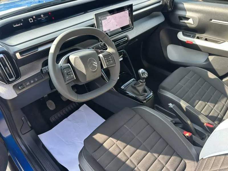Vue intérieure côté conducteur de la Citroën C3 1.2 Turbo 2025 avec tableau de bord noir et écran tactile GPS.