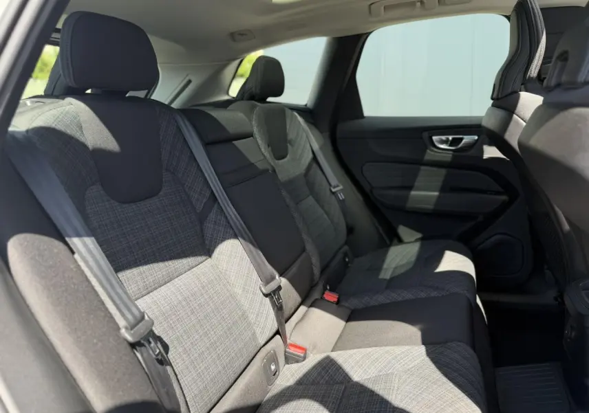Vue intérieure côté droit des sièges arrière en tissu gris à motifs du Volvo XC60 T6 AWD PHEV 2024.