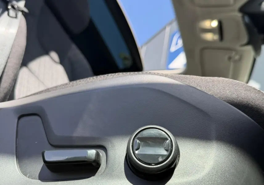 Détail du réglage manuel du siège avant gris dans l'habitacle d'un Volvo XC60 blanc Crystal 2024.