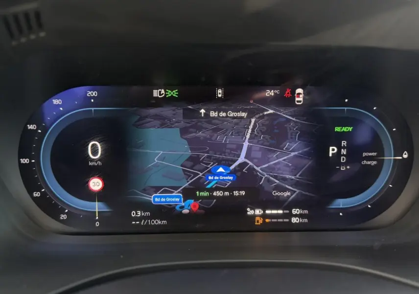 Combiné d'instruments digital du Volvo XC60 blanc, affichage navigation et vitesse à 0 km/h en vue frontale.