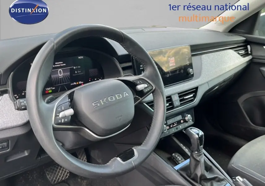 Vue intérieure centrée sur le volant cuir et tableau de bord numérique de la Skoda Scala 2025 gris métallique.