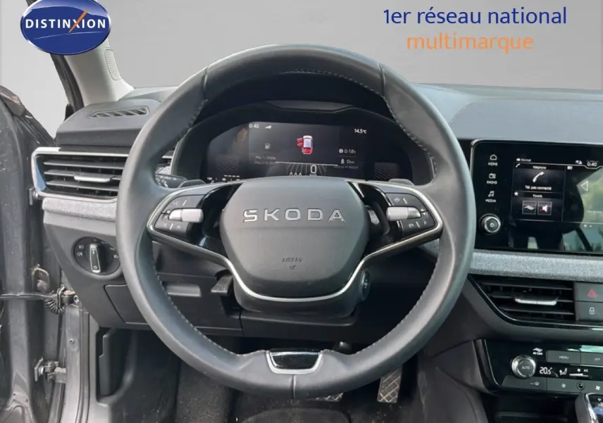 Vue intérieure centrée sur le volant SKODA d'une Scala 2025, avec tableau de bord digital et écran tactile gris magnétique.
