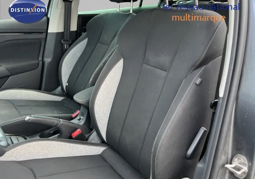 Vue intérieure côté gauche montrant les sièges avant en tissu gris clair et noir d'une Skoda Scala 2025 gris magnétique.