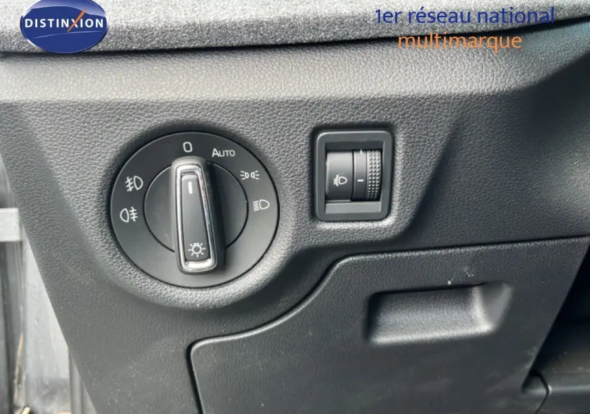 Gros plan sur les commandes d'éclairage intérieures en plastique noir dans une Skoda Scala gris magnétique.