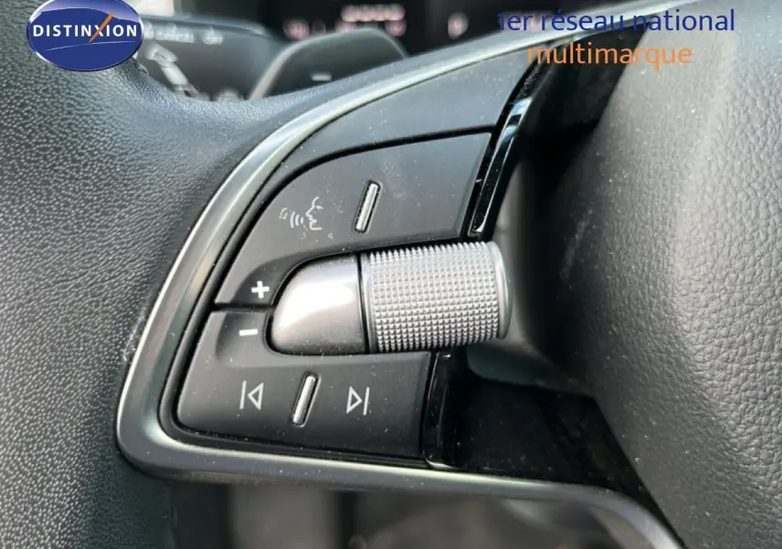 Gros plan sur les commandes multifonctions en métal et plastique noir du volant d'une Skoda Scala gris magnétique 2025.