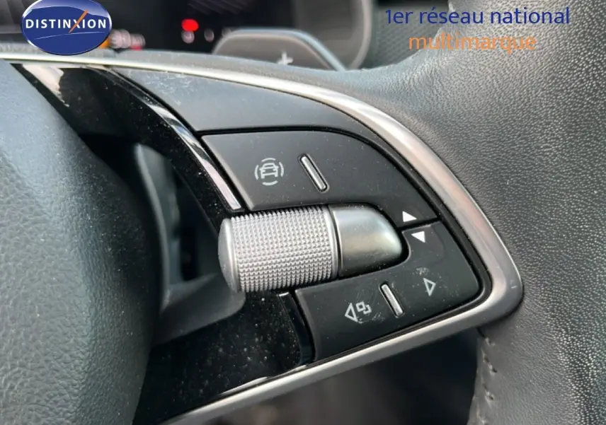 Gros plan sur les commandes multifonctions en métal et plastique noir du volant d'une Skoda Scala gris magnétique 2025.