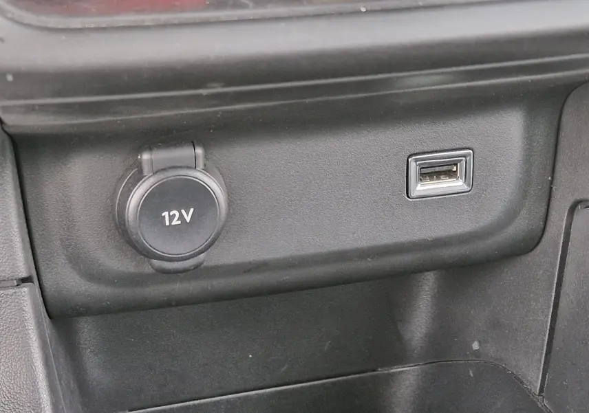 Prise 12V et port USB en gros plan sur la console centrale intérieure d'une Citroën C3 Société blanche.