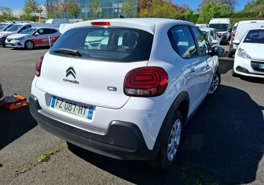 Vue 3/4 arrière droite d'une Citroën C3 Société blanche de 2021 avec feux arrière distinctifs et pare-chocs noir.