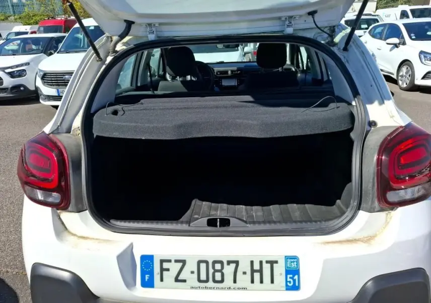 Vue arrière ouverte d'une Citroën C3 Société blanche de 2021, coffre vide et hayon levé en extérieur.