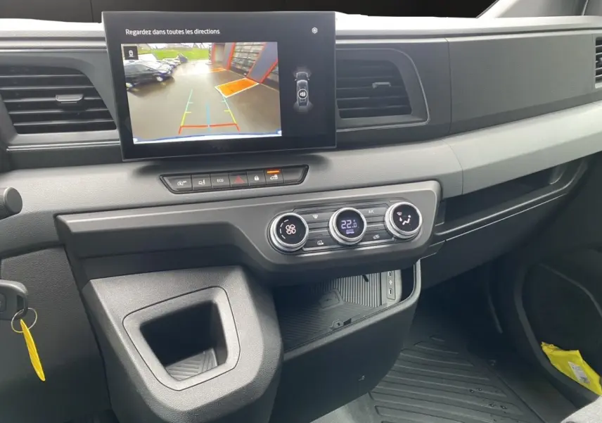 Vue intérieure du tableau de bord du Renault Master 2026, avec écran tactile affichant la caméra de recul et commandes climatisation.