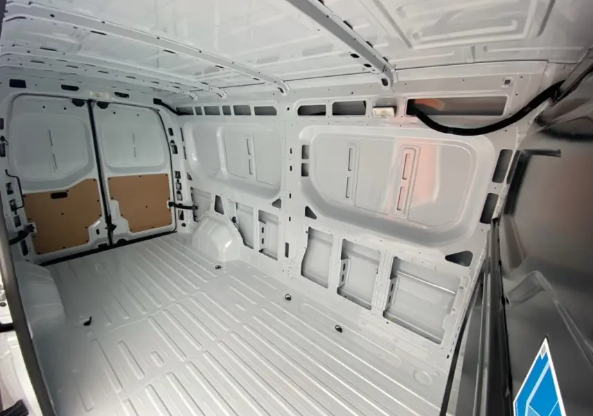 Vue intérieure arrière du Renault Master blanc, montrant l’espace de chargement vide et la cloison pleine.
