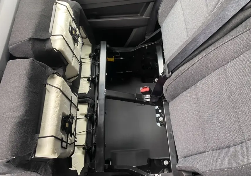 Vue rapprochée de l'intérieur arrière du Renault Master blanc, montrant les sièges rabattus et la structure métallique.