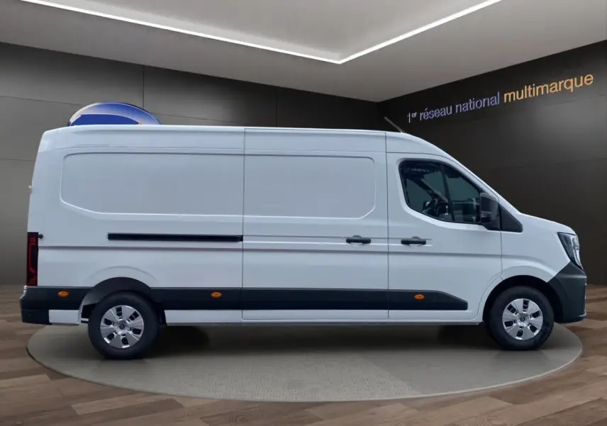 Vue de profil côté gauche d’un Renault Master blanc, fourgon long avec protections noires et jantes argentées.