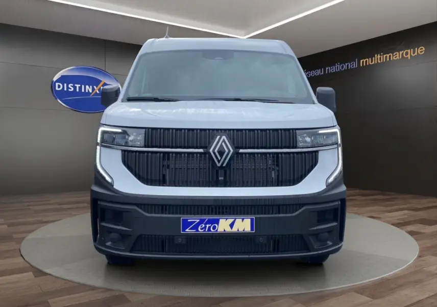 Vue de face du Renault Master blanc avec calandre noire et phares LED, présenté en showroom multimarque.