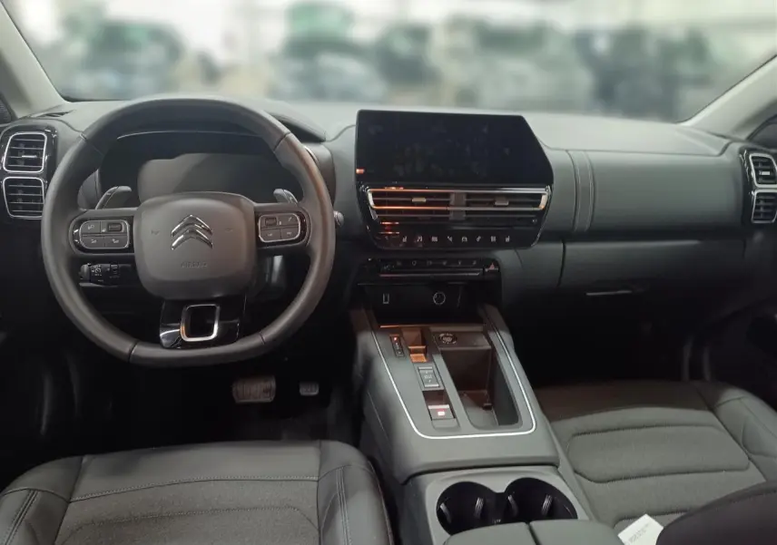 Vue intérieure avant du Citroën C5 Aircross Hybrid noir Perla, avec tableau de bord moderne et écran tactile central.