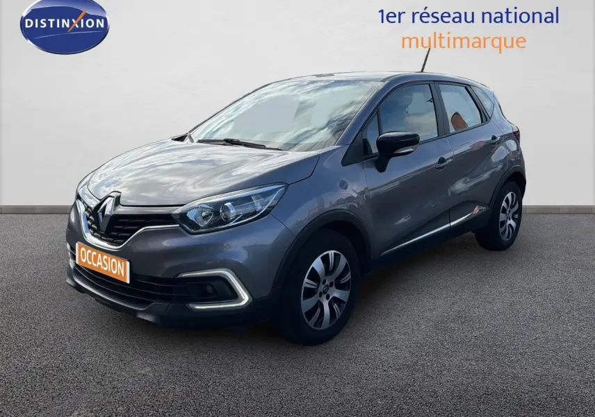 Renault Captur gris cassiopée en 3/4 avant droit, avec feux LED et jantes alliage bicolores visibles.