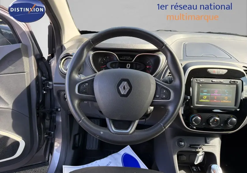 Vue intérieure centrée sur le volant Renault d’un Captur gris Cassiopée 2019 avec tableau de bord et écran tactile visibles.