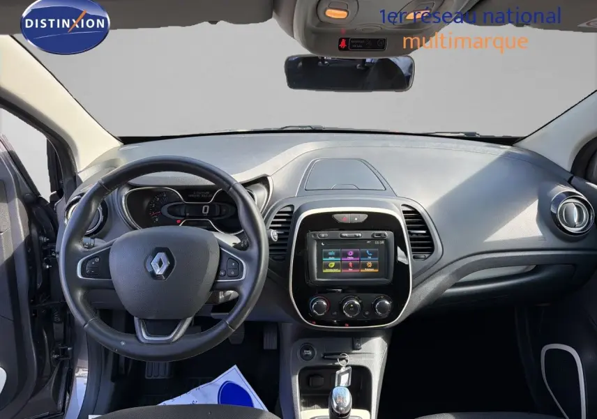 Vue intérieure du tableau de bord du Renault Captur gris Cassiopée 2019, avec volant, écran tactile et boîte manuelle.