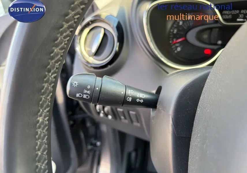 Gros plan sur la manette de commande des feux à gauche du volant du Renault Captur gris Cassiopée, intérieur visible.