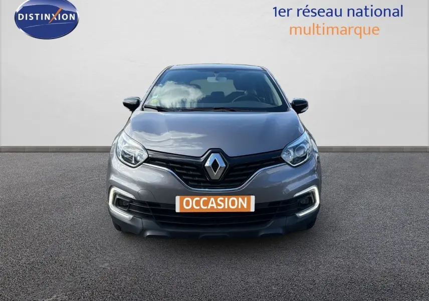 Vue frontale d’un Renault Captur gris Cassiopée 2019 avec feux diurnes LED allumés sur fond neutre.