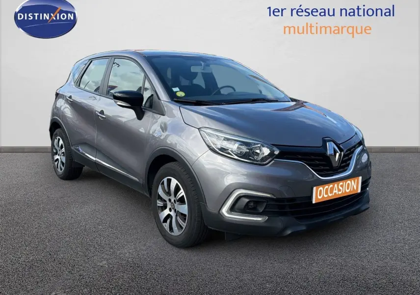 Renault Captur Zen gris Cassiopée en 3/4 avant droit, avec jantes bi-ton et calandre noire distinctive.