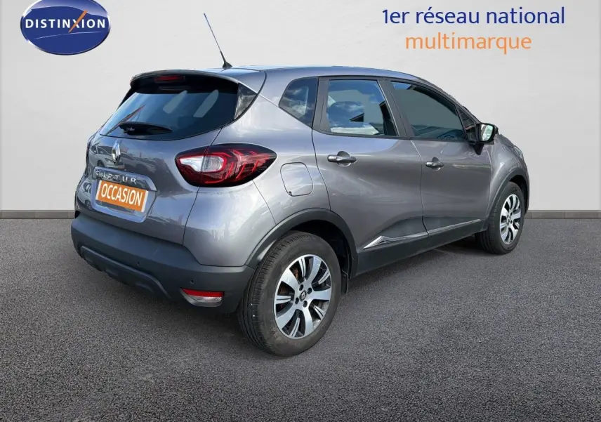 Vue 3/4 arrière droite d'un Renault Captur gris Cassiopée 2019 avec jantes alliage bicolores et vitres teintées.