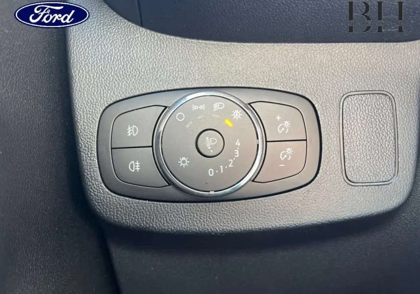 Commande des feux avec réglage d'intensité lumineuse sur tableau de bord noir d'une Ford Puma 2024 gris Solar.