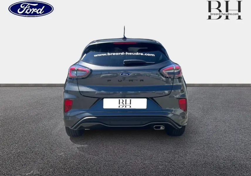 Vue arrière d'un Ford Puma 2024 gris Solar métallisé avec vitres arrière surteintées et échappement visible côté droit.