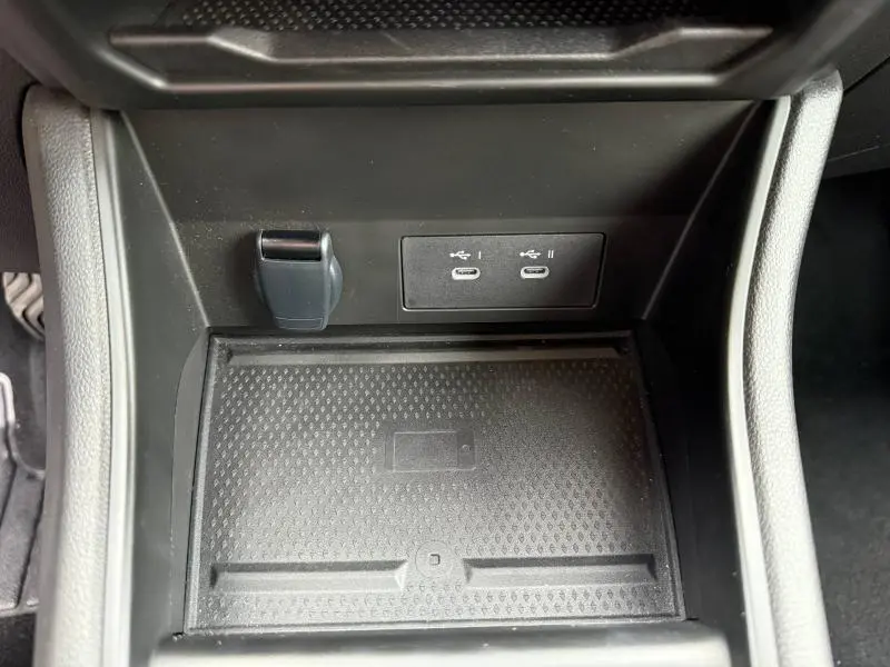 Vue rapprochée de la console centrale du Renault Captur 2025, montrant un espace de recharge sans fil et deux ports USB-C.