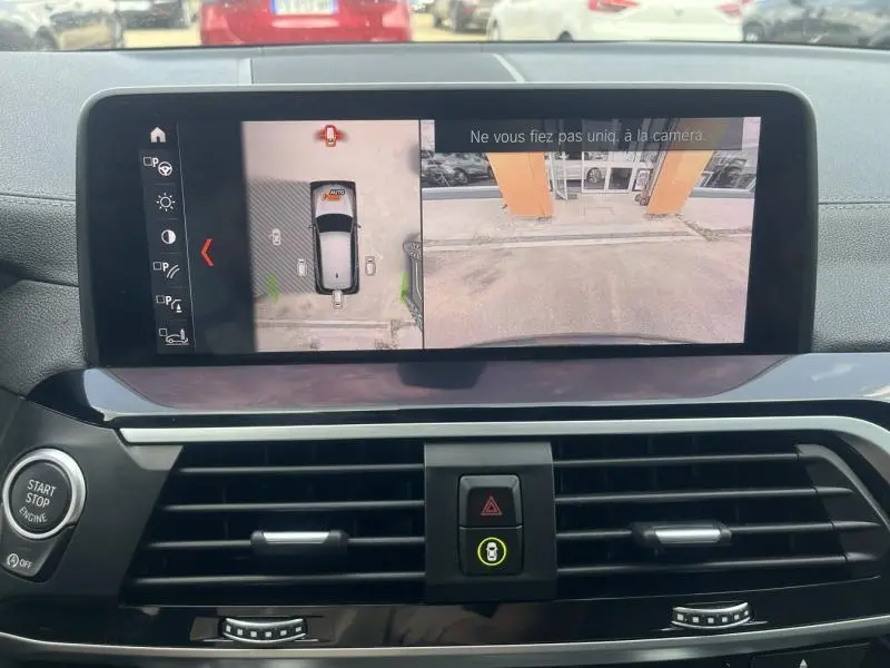 Écran multifonction intérieur montrant la caméra de recul et vue 360° du BMW X3 Sophistograu métallisé.