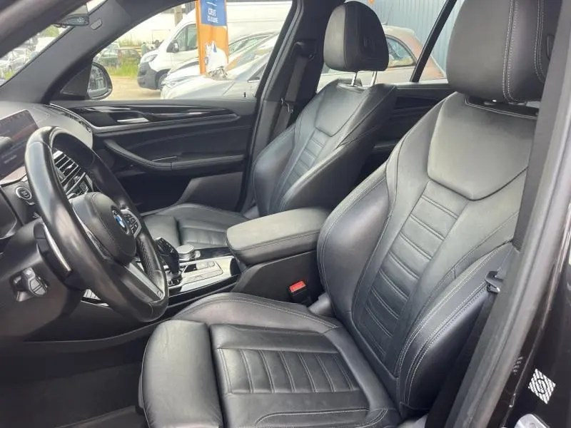 Intérieur avant de BMW X3 M40iA 2019 avec sièges cuir Vernasca noirs et console centrale visible côté gauche.