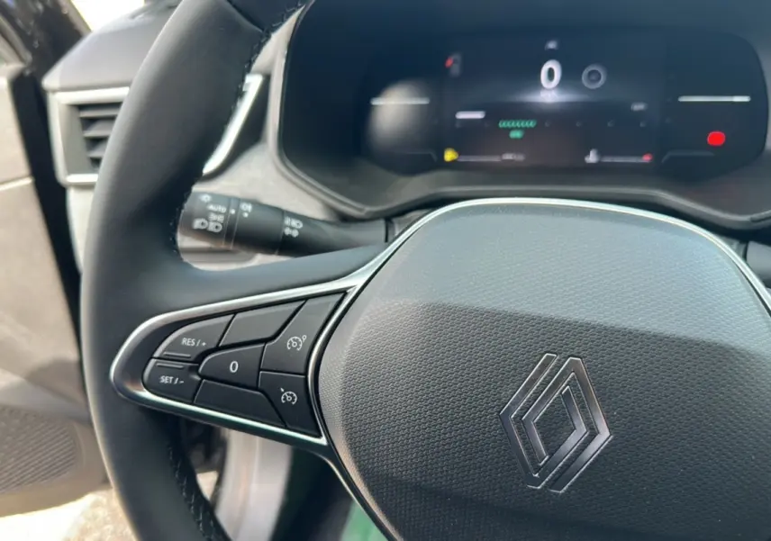 Gros plan sur le volant noir de la Renault Clio DCI 100 Evolution 2025, avec commandes intégrées et tableau de bord numérique.