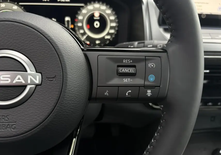 Gros plan sur le volant cuir du Nissan Qashqai 2025, côté droit avec commandes de régulateur et assistance conduite.