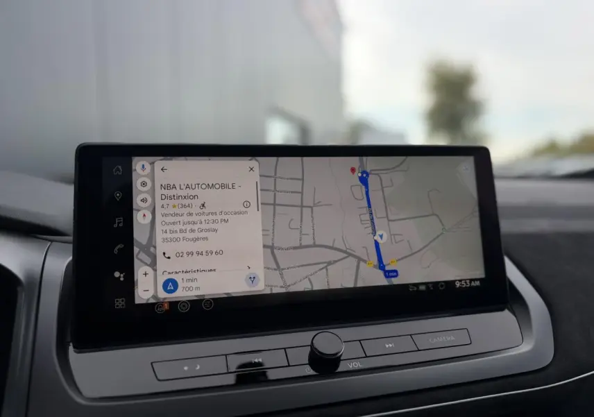 Écran tactile du GPS affichant un itinéraire dans l'habitacle du Nissan Qashqai gris Ceramic, vue rapprochée du tableau de bord.