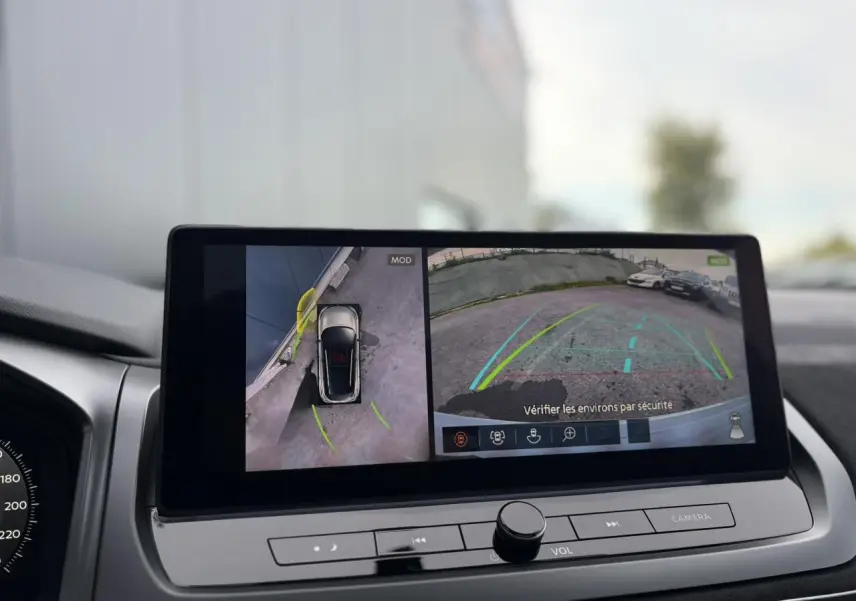 Écran tactile du Nissan Qashqai 2025 affichant la caméra 360° et vue arrière en stationnement, intérieur gris.