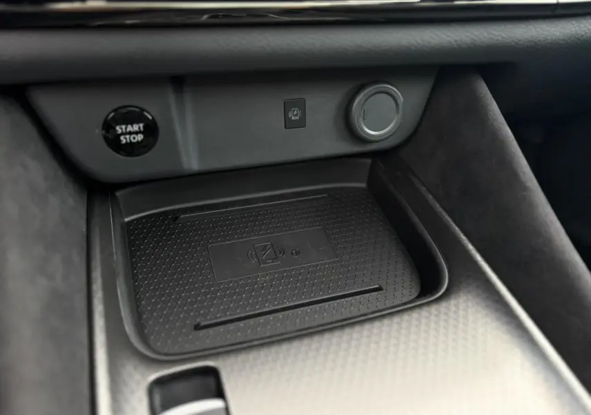 Gros plan sur le chargeur à induction et bouton start/stop dans l'habitacle du Nissan Qashqai gris Ceramic 2025