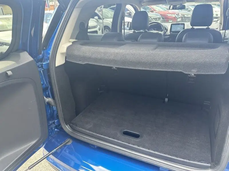 Coffre ouvert vu de l'arrière d'un Ford Ecosport bleu métal 2018, montrant l'espace de chargement et la plage arrière.