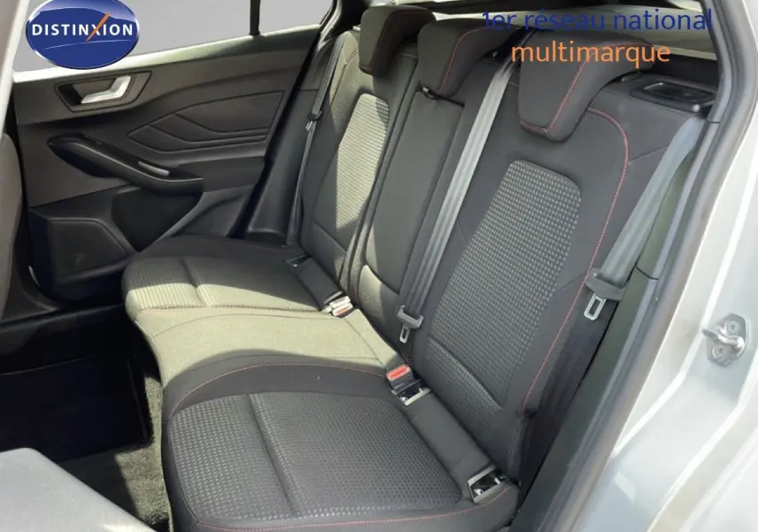 Vue intérieure côté gauche sur la banquette arrière en tissu noir avec surpiqûres rouges d'une Ford Focus SW gris lunaire 2023.
