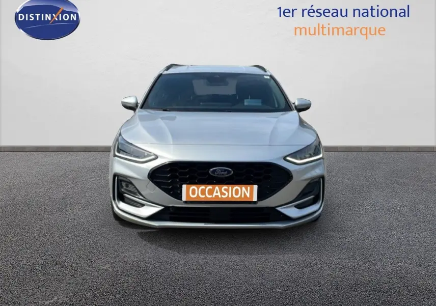 Vue avant d'une Ford Focus SW gris lunaire métal avec calandre noire et plaque "OCCASION" visible.