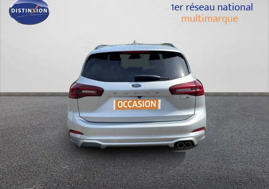 Vue arrière d'une Ford Focus SW gris lunaire métallisé avec double sortie d'échappement et vitrage arrière teinté.