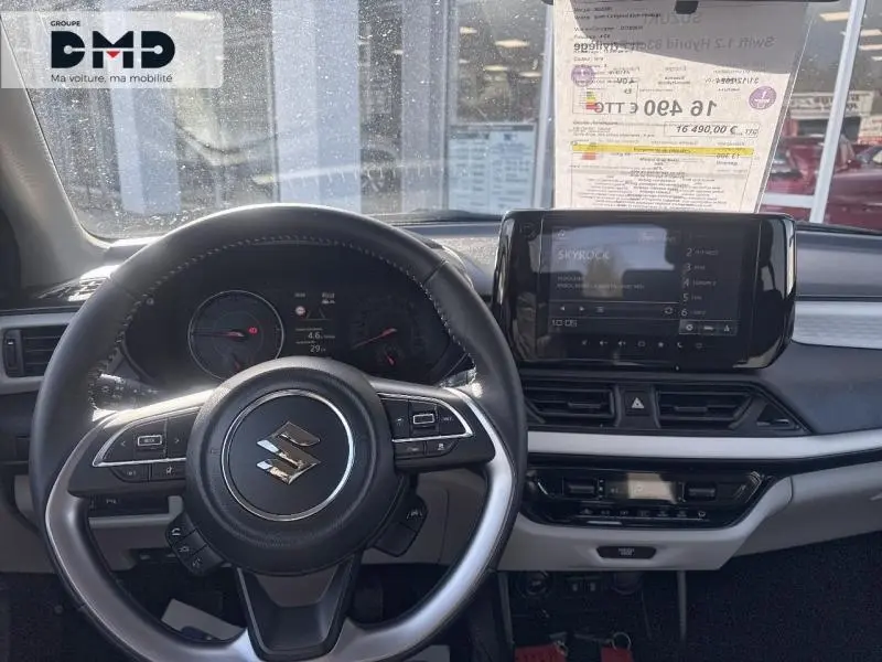 Vue intérieure frontale du tableau de bord de la Suzuki Swift 1.2 Hybrid 83ch Privilège avec volant cuir multifonction et écran tactile.