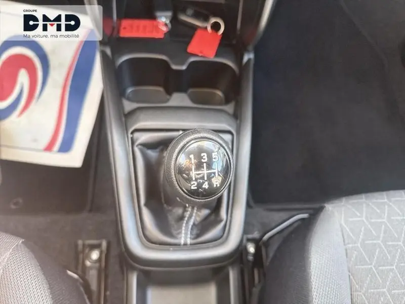 Vue plongeante sur le levier de vitesse manuel noir de la Suzuki Swift 1.2 Hybrid 2024, intérieur tissu gris.