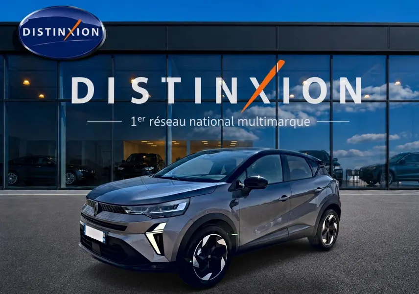 Renault Captur 2026 gris Cassiope toit noir en 3/4 avant droit, avec jantes alu et feux LED distinctifs.